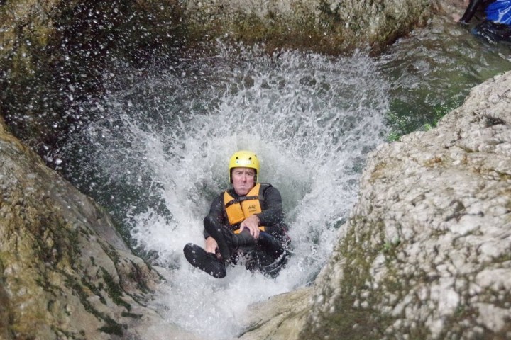 a man riding a wave on top of a rock