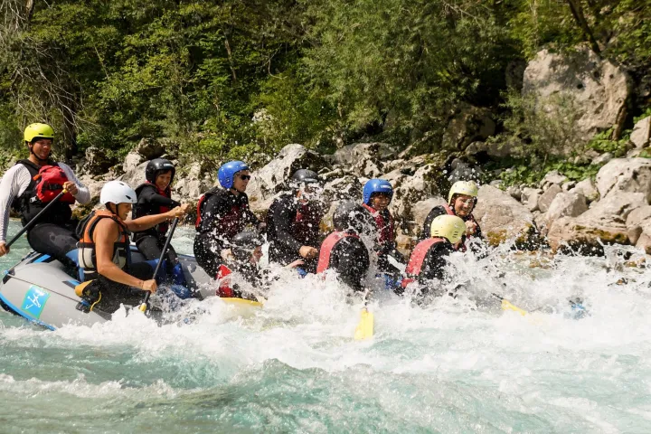 a group of people riding skis on a raft in the water