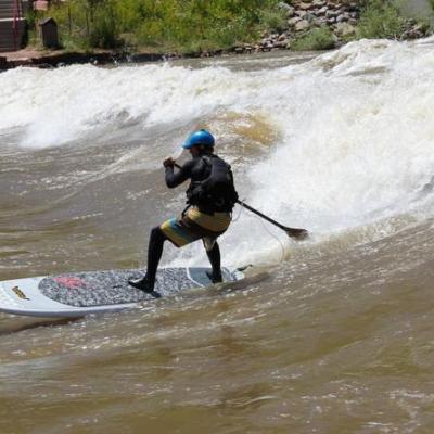 a man riding a wave on a surf board on a body of water