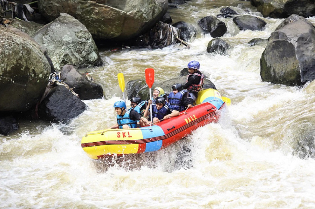 Group white-water rafting in rocky river.